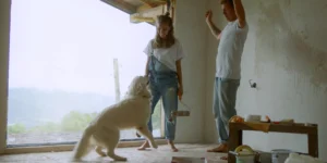 couple of young people dancing with the dog amidst renovation